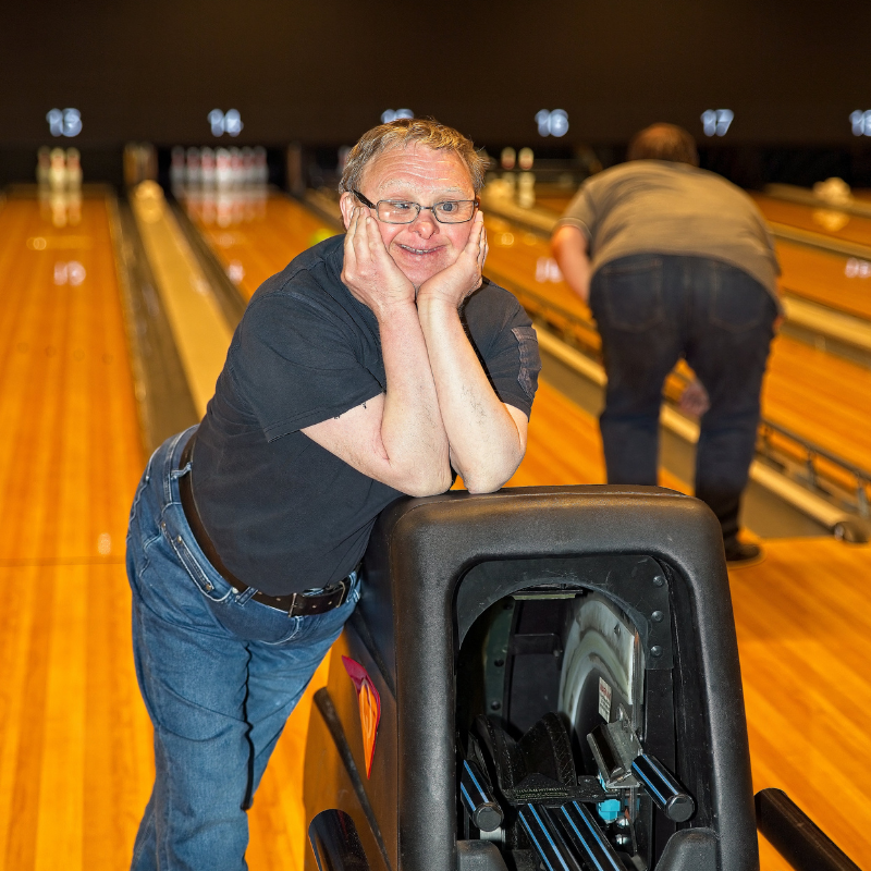 Bilden visar Anders som är nöjd med resultatet på bowlingen tillsammans med sin personliga assistent