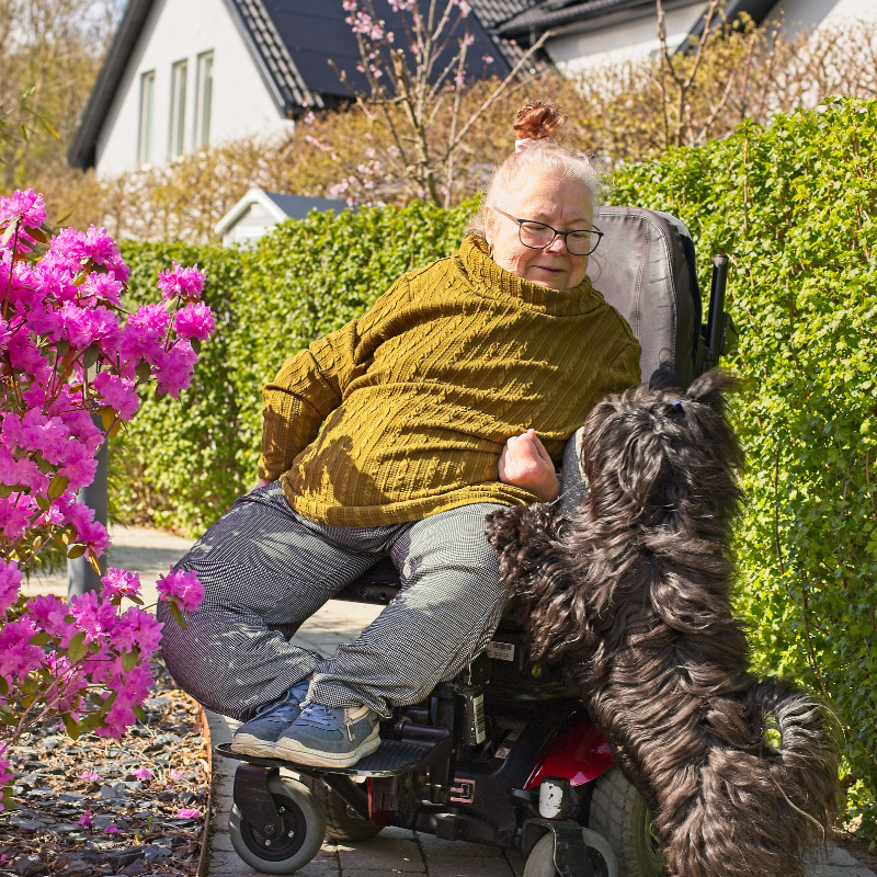 Bilden visar Anki med hund i sin trädgård